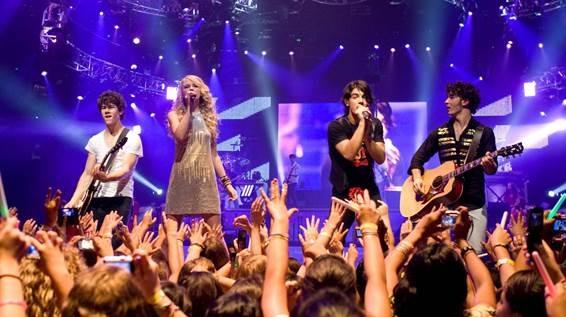 Palco com banda pessoas cantando e tocandoO conteúdo gerado por IA pode estar incorreto.
